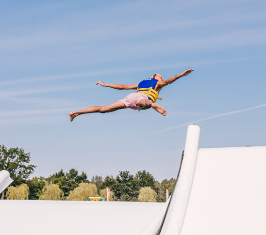 Jongen gaat van de super slide, de grootste glijbaan van Nederland bij Fun Beach in Panheel, Limburg.