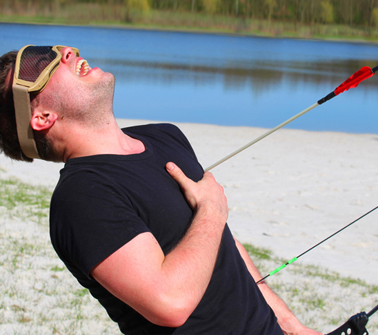 Een man die wordt geraakt met een pijl bij archery tag. Een mix tussen trefbal en boogschieten. Leuke activiteit tijdens een sportdag, personeelsuitje, bedrijfsuitje, familiedag of vrijgezellenfeest in Limburg.