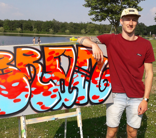 Iemand toont het kunstwerk dat hij gemaakt heeft tijdens de graffiti workshop bij Fun Beach Group Events in Panheel, Limburg.