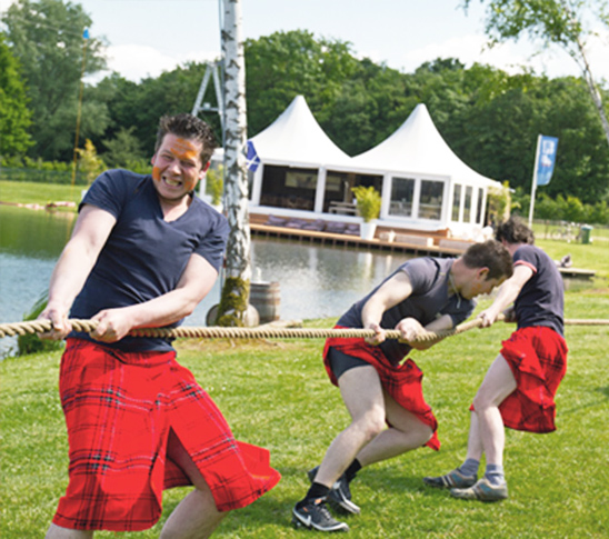 Jongens die deelnemen aan de schotse hoogland games tijdens een vrijgezellenfeest of vriendenweekend in Midden-Limburg.