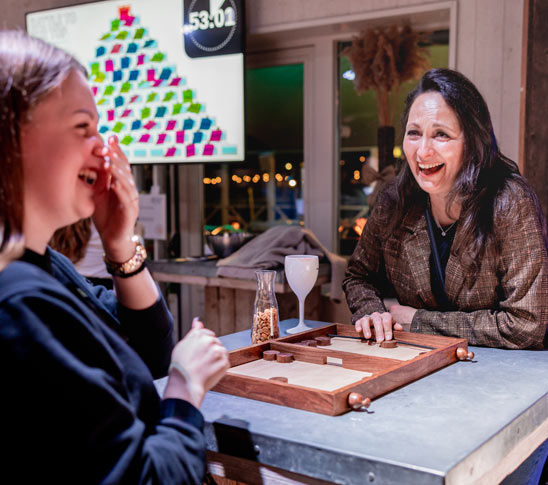 Twee mensen zijn een minigame aan het doen tijdens een leuk personeelsuitje in Limburg.