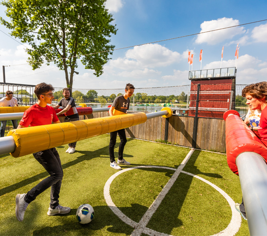 Mensen die levend tafelvoetbal spelen tijdens een sportdag in Midden-Limburg.