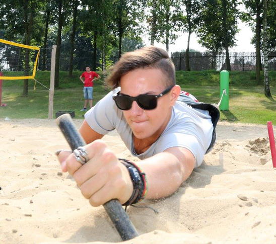 Een man die aan een bungeekoord vastzit en bungee run doet. Een leuke activiteit voor een sportdag in Midden-Limburg.