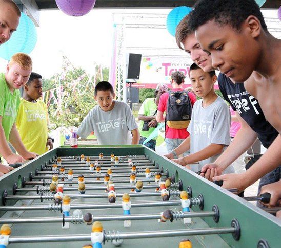 Een groep kinderen spelen reuze tafelvoetbal tijdens een kinderfeestje, schoolreisje of sportdag bij Fun Beach in Midden-Limburg.