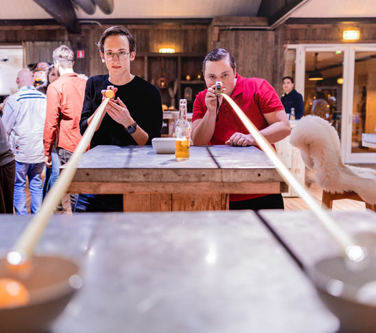 Twee mensen zijn een minigame aan het doen tijdens een leuk personeelsuitje in Limburg.