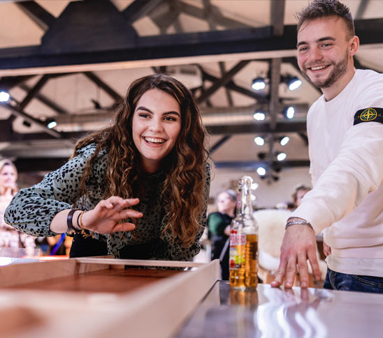 Twee mensen zijn een minigame aan het doen tijdens een leuk personeelsuitje in Limburg.