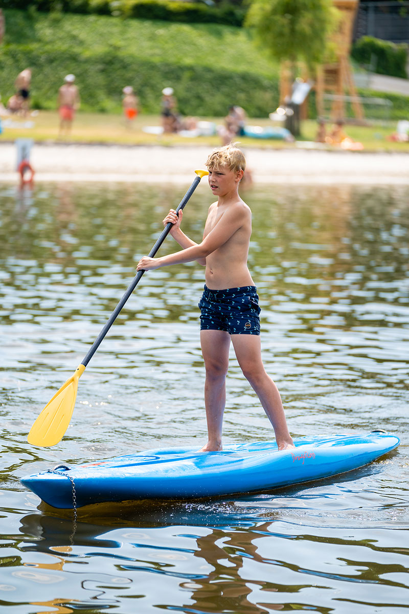 Jongen op een supboard op het water van Fun Beach in Panheel, Limburg. Het leukste dagstrand van Nederland.