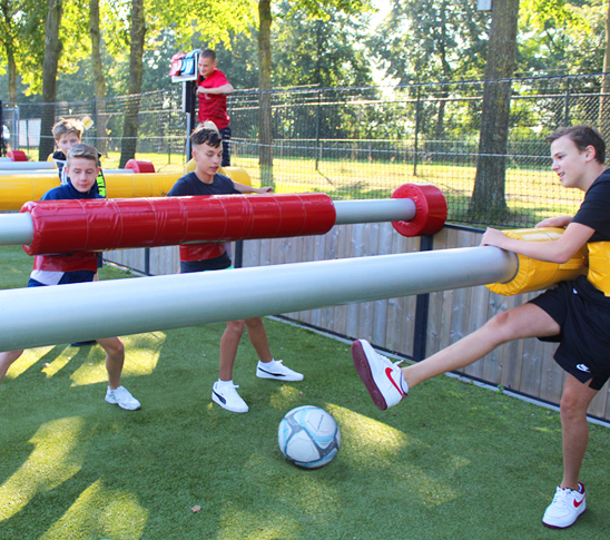 Kinderen die levend tafelvoetbal spelen tijdens een sportdag in Midden-Limburg.