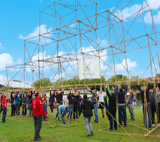 Teambuilding door middel van bamboebuilding. Dit is een kaartenhuis bouwen met bamboestokken.