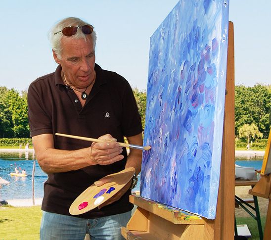 Een man die op een schildersdoek schildert en les geeft in schilderen tijdens een Picasso workshop.